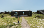 Moderne tiny house Est bij Vakantiepark De Klepperstee in Nederland, omgeven door gras.