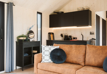 Moderne woonkamer en kitchenette in tiny house Est bij Holiday park De Klepperstee, Nederland.