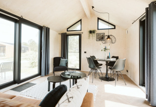 Interno luminoso e moderno della tiny house Est al Holiday park De Klepperstee, Paesi Bassi.