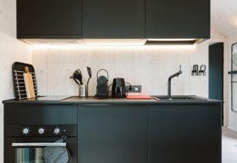 Moderne zwarte keuken in het tiny house Est bij Holiday Park De Klepperstee, Nederland, strak en minimalistisch.