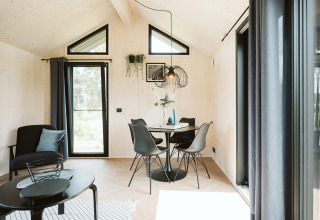 Moderne, lichte woon- en eethoek in tiny house Est op vakantiepark De Klepperstee, Nederland.