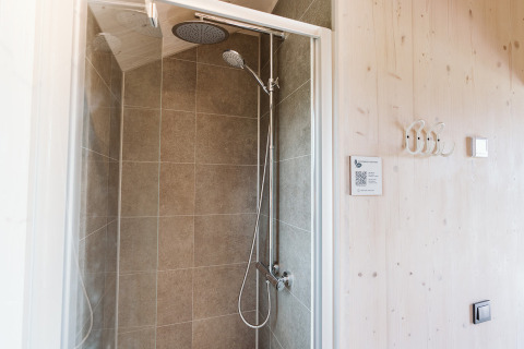 Moderne Dusche mit grauen Fliesen in einem Tiny House im Ferienpark De Klepperstee, Niederlande.
