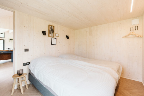 Acogedor dormitorio con cama doble en tiny house Est en Holiday park De Klepperstee, Países Bajos.