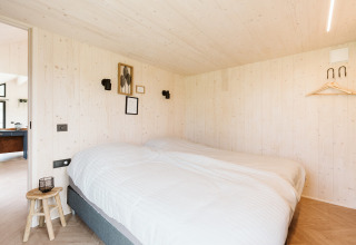 Acogedor dormitorio con cama doble en tiny house Est en Holiday park De Klepperstee, Países Bajos.