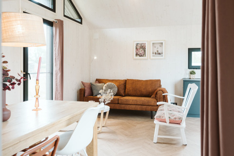 Sala luminosa y acogedora en la tiny house Scandic del Holiday park De Klepperstee en los Países Bajos.