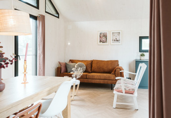 Sala luminosa y acogedora en la tiny house Scandic del Holiday park De Klepperstee en los Países Bajos.