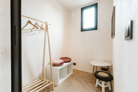 Stanza minimalista nella tiny house Scandic al Holiday park De Klepperstee, Paesi Bassi, con arredo in legno.