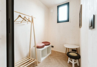 Stanza minimalista nella tiny house Scandic al Holiday park De Klepperstee, Paesi Bassi, con arredo in legno.