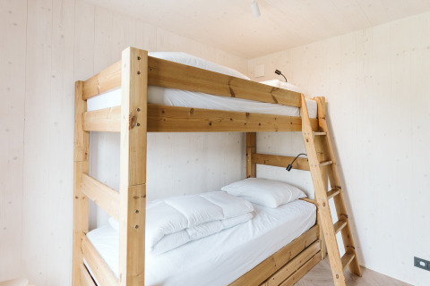 Lichte, minimalistische slaapkamer met houten stapelbed in tiny house Scandic bij Holiday park De Klepperstee.