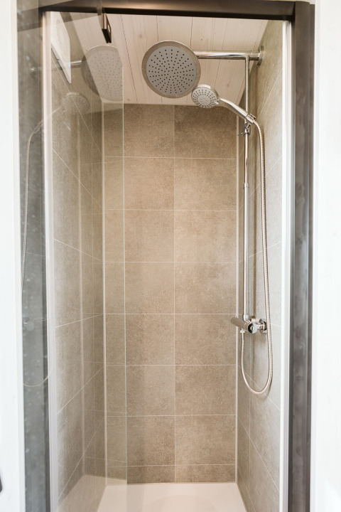 Moderne douche met regendouche en handdouche in Scandic tiny house bij De Klepperstee, Nederland.