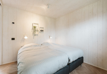 Chambre lumineuse avec deux lits simples dans Tiny Rebel, Holiday park De Klepperstee, aux Pays-Bas.