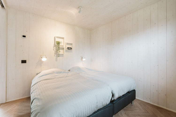 Lichte slaapkamer met twee eenpersoonsbedden in Tiny Rebel, Holiday park De Klepperstee, Nederland.