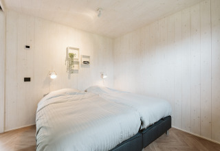 Chambre lumineuse avec deux lits simples dans Tiny Rebel, Holiday park De Klepperstee, aux Pays-Bas.