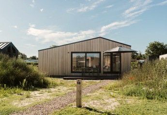 Foto des Tiny House Backer im Ferienpark De Klepperstee, Niederlande, mit moderner Fassade und Terrasse.