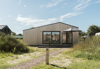 Photo de la tiny house Backer au parc de vacances De Klepperstee aux Pays-Bas, façade moderne en bois.