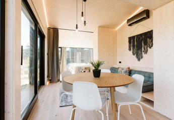 Modernes, helles Tiny House Backer im Holiday park De Klepperstee, mit Essbereich und großen Fenstern.