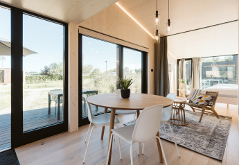 Casa pequeña luminosa y moderna en Holiday park De Klepperstee con grandes ventanales y vistas naturales.