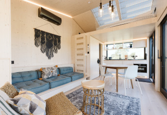 Lichte en moderne tiny house met gezellige zithoek, eetplaats en keuken in Holiday park De Klepperstee, Nederland.