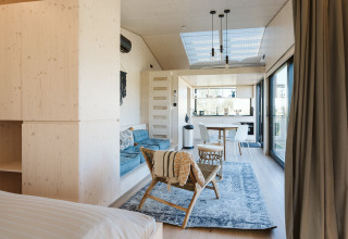 Interior luminoso y moderno de una tiny house en Holiday park De Klepperstee, Países Bajos, con espacio abierto.