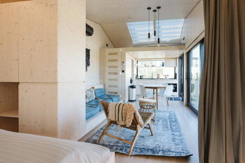 Interior luminoso y moderno de una tiny house en Holiday park De Klepperstee, Países Bajos, con espacio abierto.