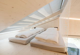 Luminoso altillo con dos camas individuales en Backer tiny house en Holiday park De Klepperstee, Países Bajos.