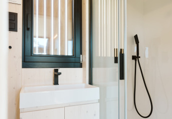 Salle de bain moderne et compacte d’une tiny house au Holiday park De Klepperstee, Pays-Bas.