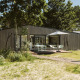 Lodge moderno en el parque vacacional De Klepperstee, Países Bajos, con terraza, madera y sombrilla.