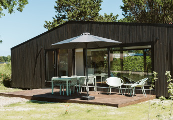 Terrasse moderne avec meubles extérieurs et parasol au lodge Eden, Holiday park De Klepperstee, Pays-Bas.
