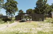 Moderne Eden-Lodge im Ferienpark De Klepperstee in den Niederlanden mit Terrasse und Gartenmöbeln.