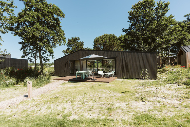 Lodge Eden moderno en el parque vacacional De Klepperstee, Países Bajos, con terraza y muebles exteriores.