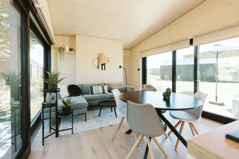 Modern lodge-interieur in Eden bij Holiday park De Klepperstee, Nederland, met grote ramen en veel licht.