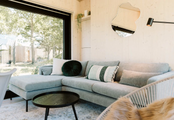 Helles, modernes Wohnzimmer in der Eden-Lodge im Holiday Park De Klepperstee, Niederlande, mit Gartenblick.