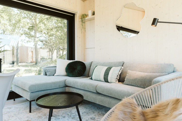 Helles, modernes Wohnzimmer in der Eden-Lodge im Holiday Park De Klepperstee, Niederlande, mit Gartenblick.