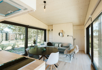 Moderne lodge met grote ramen en stijlvolle inrichting bij Eden in vakantiepark De Klepperstee, Nederland.