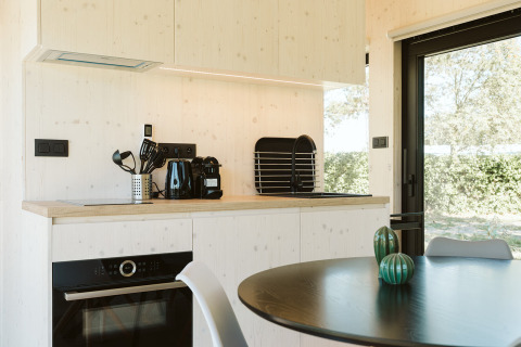 Moderne kitchenette in de Eden-lodge bij Holiday park De Klepperstee, Nederland, uitzicht op buiten.