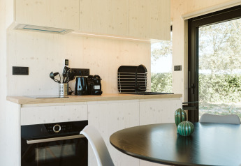 Moderne kitchenette in de Eden-lodge bij Holiday park De Klepperstee, Nederland, uitzicht op buiten.