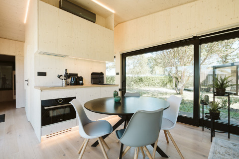 Moderne eet- en keukenhoek in de Eden-lodge bij Holiday park De Klepperstee met grote ramen en uitzicht op natuur.