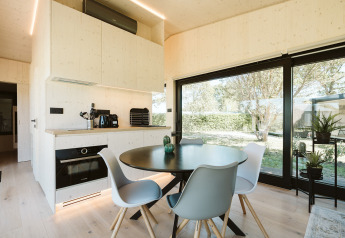 Moderne eet- en keukenhoek in de Eden-lodge bij Holiday park De Klepperstee met grote ramen en uitzicht op natuur.