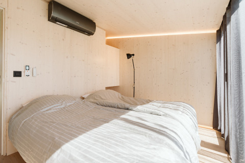 Slaapkamer in Eden lodge bij Holiday park De Klepperstee, Nederland, met tweepersoonsbed en zonlicht.