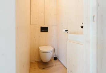 Moderne houten badkamer met hangend toilet en wastafel in Eden, Holiday park De Klepperstee, Nederland.
