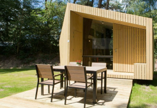 Casa pequeña moderna Trek-in en Beerze Bulten, Países Bajos, con terraza de madera y muebles de exterior.