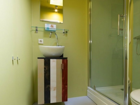 Bagno moderno in una tiny house Trek-in a Beerze Bulten, Paesi Bassi, con doccia e mobile lavabo colorato.