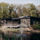 Luxury Family Water Lodge with hot tub at Soof Retreats in the Netherlands, surrounded by forest and pond.