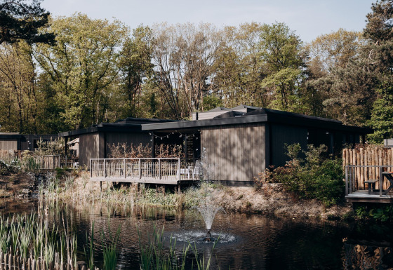 Luxe Family Water Lodge met bubbelbad bij Soof Retreats in Nederland, aan het water en omgeven door bos.