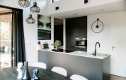 Cocina moderna de lodge con decoración en blanco y negro, arte en la pared, reloj y gran ventana luminosa.