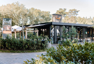 Soof Boutique Lodge met uitnodigend terras, omgeven door groen en een welkomstbord aan de voorkant.