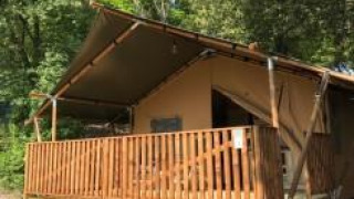 Safari-telt med sanitære faciliteter og træterrasse, Camping Mar y Sierra, omgivet af natur i Italien.