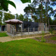 Cabaña moderna Heiberg en Hoge Kempen, Bélgica, con terraza, sombrilla y rodeada de bosque verde.
