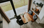 Overhead view of dining nook inside Tiny house XL at Camping Si-Es-An, featuring sofa and deer artwork.