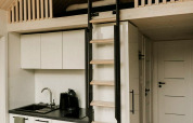Modern tiny house with loft, ladder, and kitchenette at Camping Si-Es-An in the Netherlands.